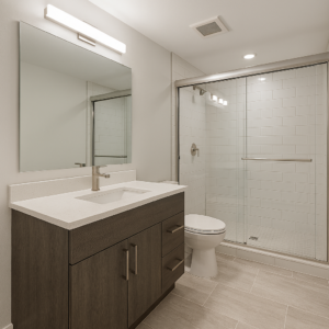 Modern basement bathroom with walk‑in glass shower, tile flooring, and contemporary vanity