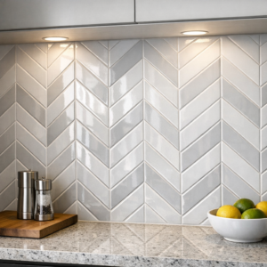 Modern kitchen backsplash featuring a chevron-patterned ceramic tile design with subtle grout lines and under-cabinet lighting highlighting the texture.