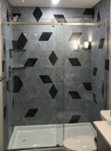 Custom Tile Pattern with Mixed Tile Colours and Variation in Design on Shower Walls. 